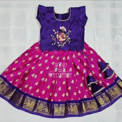 A beautiful purple and pink pattu pavadai for newborns. The purple blouse has delicate floral embroidery, and the outfit includes extra margins for extended wear.
