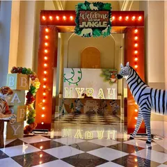 Another view of the spectacular jungle entrance, with a checkered floor reflecting the warm marquee lights. The life-sized animal props and "Welcome to the Jungle" sign promise a wild celebration.