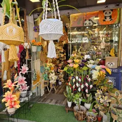 The entrance to my store is always filled with colorful and interesting items, from artificial flowers to macrame hangers, giving you a taste of what's inside.