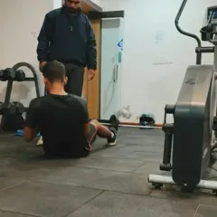 A home training session in progress. I'm guiding my client through a core exercise, ensuring he maintains proper form even in a home gym setting.
