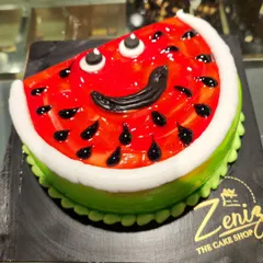 A slice of summer in cake form! This fun novelty cake is designed to look exactly like a juicy slice of watermelon, complete with a green rind, red fruit, and edible "seeds."