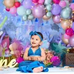Our 'Little Mermaid' theme is perfect for a magical first birthday. This little girl looks adorable in her mermaid costume against our under-the-sea backdrop.