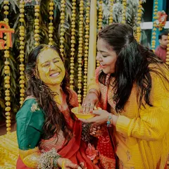 A sweet moment between sisters during the haldi. The genuine smiles and gentle application of turmeric paste show the love and bonding that these rituals are all about.