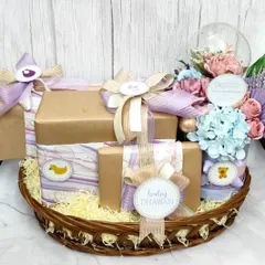 A special baby shower basket for the Dhawan family. This hamper is filled with beautifully wrapped gifts in a pastel purple and blue theme, complete with a floral arrangement in a dome.
