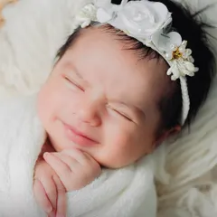 A sleepy, crinkly-nosed smile is one of the most precious moments. I gently swaddle newborns in soft fabrics to keep them feeling secure and content.