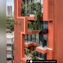 In the dense urban landscape of Mumbai, we sculpted a vertical oasis. This close-up of the Sarvasva tower shows how we integrated cascading greenery and a sculptural spiral staircase, turning the building's facade into a living, breathing garden.