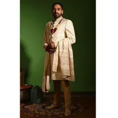 This full length view showcases the complete royal ensemble. The ivory sherwani is paired with a matching embroidered stole and churidar, creating a cohesive and commanding presence for a wedding ceremony.