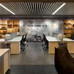 For the Harley-Davidson workspace, we translated the brand's iconic identity into a physical environment. This open-plan office features a custom mural with the tagline "The Look, The Sound, The Feel," surrounded by raw, industrial materials and displays of motorcycle parts, creating a space that authentically reflects the company's culture.