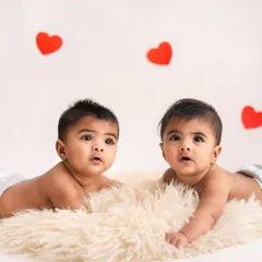 Tummy time is twice as cute with twins! These brothers are lying side-by-side on a soft rug during their half-birthday milestone session.