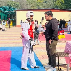 Strategic advice is just as important as physical training. This photo captures a key coaching moment with Ansh Sharma during the Delhi Olympic Games.