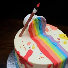 A close-up of the fondant details on the artist cake. The spilling paint bucket, paintbrush, and colorful drips are all handcrafted to create a playful and edible work of art.