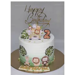 A jungle safari cake for a 2nd birthday. This chocolate truffle cake is decorated with cute animal toppers and monstera leaves, all without fondant.