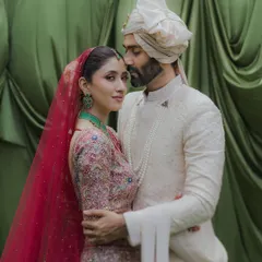 A classic portrait where the groom holds his bride close. Her gaze towards the camera and his towards her creates a beautiful dynamic, all set against a rich green backdrop at the Taj Lands End.