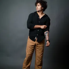 This shot highlights the model's arm tattoo and captures a candid, off-camera glance, adding personality to the series.