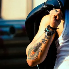 A close-up detail shot focusing on the tattoo and accessories. These shots add depth and personality to a portfolio.