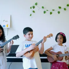 There's nothing like the sound of a group of young students strumming their ukuleles together. This photo captures the fun, friendship, and focus in our music lessons for children.