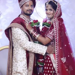 A classic portrait of a North Indian bride and groom in their coordinated wedding attire, showcasing a regal and timeless look.