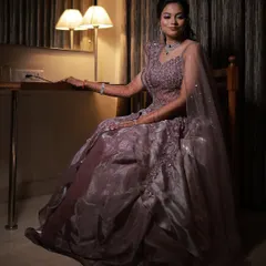 A full-length seated portrait, capturing the elegance of her sangeet gown and the soft, romantic hairstyle.