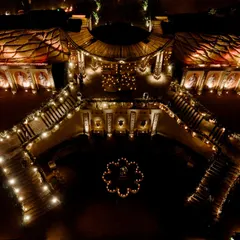A breathtaking overhead view of the 'Lost City' entryway. The design features a grand, curved staircase descending into a Baroque-style garden, all leading towards the monumental stage in the distance.