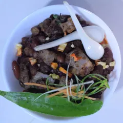 My Naga-style pork cooked with kidney beans, a traditional and filling combination. The dish is garnished with fresh herbs and spring onions for extra flavor.