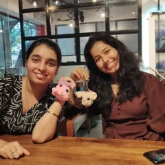 Two participants showing off the adorable crochet keychains they made in our Amigurumi workshop. Learn to stitch your own cute companions.