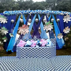 A bold and modern stage setup using a blue and white chevron pattern. The blue drapes and silver paper flowers create a cool, contemporary look for a sangeet or cocktail party.