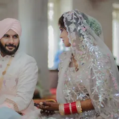 The serene and spiritual atmosphere of an Anand Karaj ceremony in a Gurudwara, capturing a quiet glance between the Sikh bride and groom.