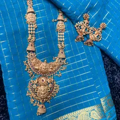 A close-up of a stunning temple jewellery long necklace and matching earrings. The intricate details and goddess motifs are what make these pieces so special.