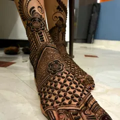 A close-up of a detailed floral and net pattern on the feet, showcasing the precision and intricacy of the work.