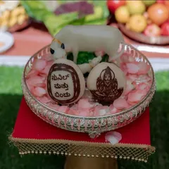 We add personal touches that make your event truly unique. Here you can see coconuts we custom-carved with a deity image and a welcome message in Kannada, placed in a silver tray with rose petals.