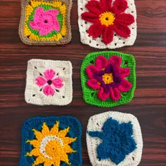 A collection of six colorful granny square coasters, each with a unique floral or sun-inspired design in the center.