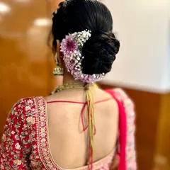 A closer look at a beautifully crafted floral bun, featuring a mix of baby's breath and purple chrysanthemums for a touch of color.