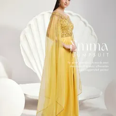 The Emma Jumpsuit in a vibrant yellow. This unique piece features an embellished off-shoulder bodice, dramatic cape sleeves, and wide-leg pleated trousers for a modern and graceful statement.