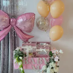 Welcoming a baby girl with all the elegance she deserves. This stunning acrylic hamper features personalized pearl lettering, designer gifts, and a cascade of fresh flowers, all tied together with a beautiful pink bow.