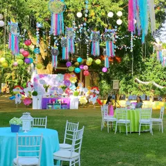 A magical unicorn birthday set in a lush garden. The decor featured rainbow dreamcatchers hanging from the trees and vibrant table settings to create a mystical and colorful atmosphere.