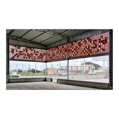 Looking from within the warehouse, our custom terracotta jali screen filters daylight and provides ventilation. This showcases how we design elements that are both functional and create a unique spatial experience for those inside.
