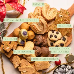 A close-up of my winter platter, showcasing the variety of my homemade snacks. You can see the labels for Palmier, Chana Hazelnut Laddoo, Til Chikki, and various cookies.