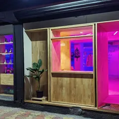 The facade glows with vibrant pink and blue light, demonstrating the transformative power of the RGB system. This feature allows the store to create different moods for product launches, events, or daily retail.