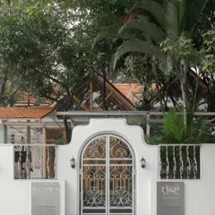 The ornate front gate of the Bake House, offering a glimpse of the tropical, garden-like cafe within. The design creates a sense of discovery and an escape from the city.