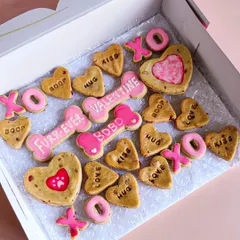 This is my assorted Valentine's biscuit box. It's full of fun, conversation-heart style cookies with words like 'Boop', 'Hug', and 'Kiss', plus personalized bone-shaped biscuits.
