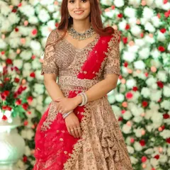 A beautiful full-length shot of a client ready for a reception. The intricately embroidered lehenga is paired with soft makeup and a modern hairstyle with loose curls.
