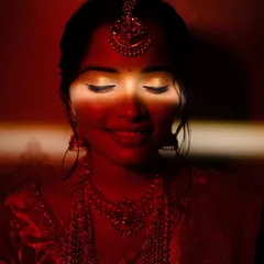 A dramatic close-up of the bride's face, with a sliver of light highlighting her eyes and smile. This artistic use of light and shadow creates a moody, intimate, and captivating portrait.