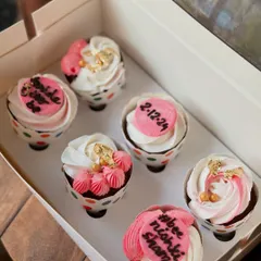 Another angle of the pink and white bridal shower cupcakes, showing the mix of piped frosting techniques and personalized details.
