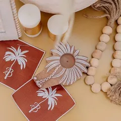 Personalization is key. For this 'Desert Oasis' theme, I designed custom coasters with a palm tree motif and the couple's initials, along with other handcrafted details like wooden beads.