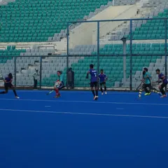 A wide view of the match, showing the strategic spacing of players across the field. We train our teams to maintain their structure during open play.