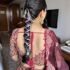 A creative and modern take on a bridal braid for a pre-wedding event. This style features a bubble braid effect, interwoven with colorful threads and finished with a traditional chained hair accessory.