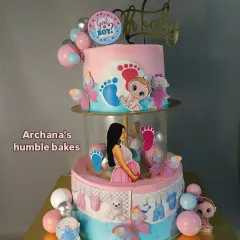 A beautiful two-tiered baby shower cake with a spacer design. The clear middle tier is filled with pink and blue balloons for a gender reveal theme.