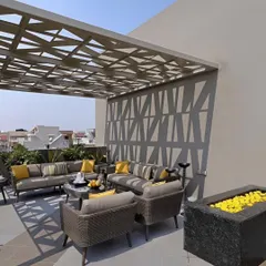 This modern terrace features a custom CNC-cut pergola that casts dynamic patterns of light and shadow. Paired with a matching privacy screen, it transforms the rooftop into a sophisticated and comfortable outdoor lounge, perfect for relaxation or entertaining.