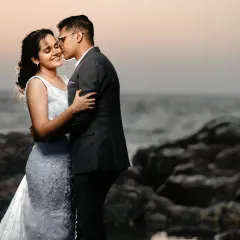 A tender kiss on the cheek against a soft sunset sky. This post-wedding portrait on the rocks is all about capturing a quiet, romantic moment in a beautiful, natural setting.