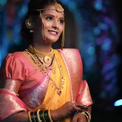 The quintessential Maharashtrian bride. This close-up highlights the traditional crescent bindi, the glow of HD makeup, and the intricate details of the nath and gold jewelry that are central to this beautiful look.
